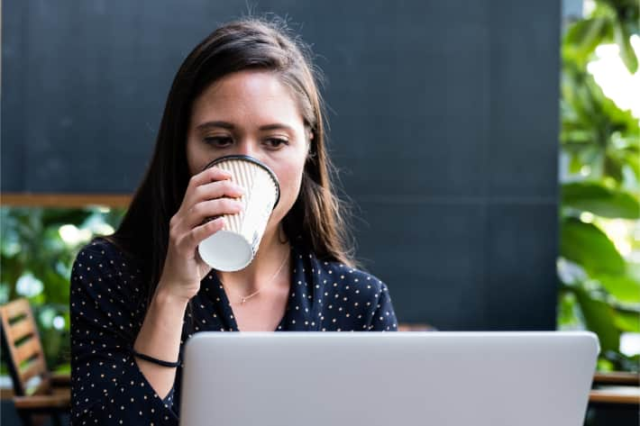 Vrouw surft op laptop en drinkt koffie